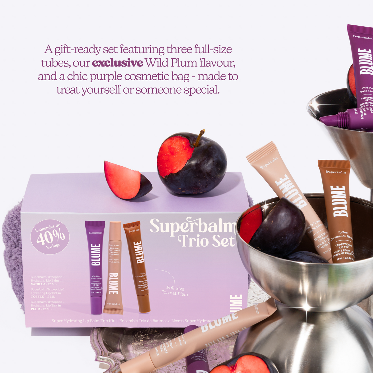 Superbalm Trio Set with cosmetic bag and plum fruit on a white background