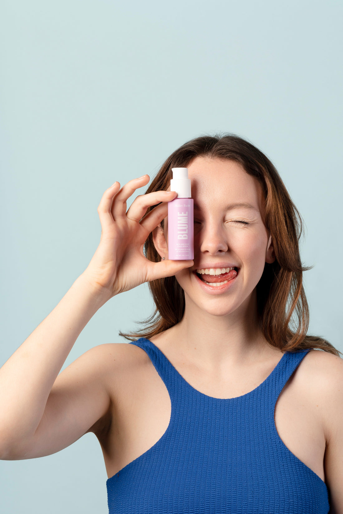 Smiling woman holding Blume Milky Fade serum for clear, even-toned skin and acne scar fading.