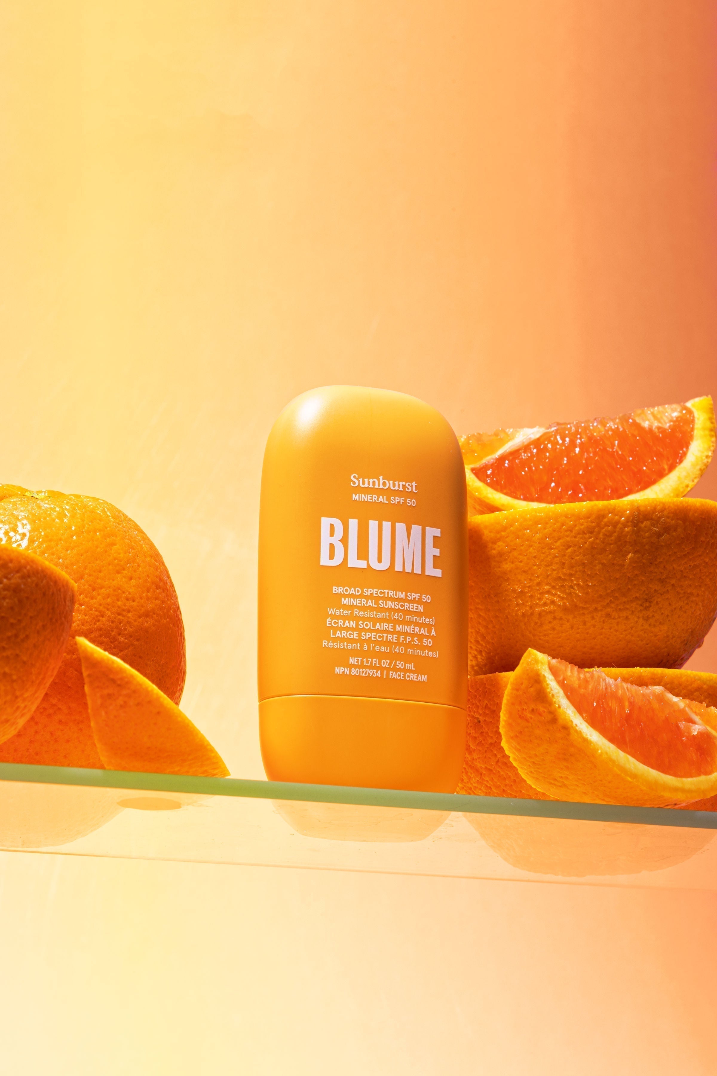 Mineral face sunscreen SPF 50 by Blume paired with fresh citrus for a clean, natural vibe.