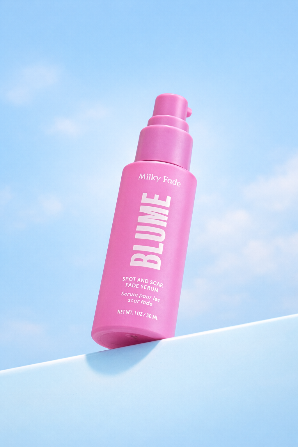 Blume Milky Fade Spot and Scar Fade Serum bottle against a light blue sky background