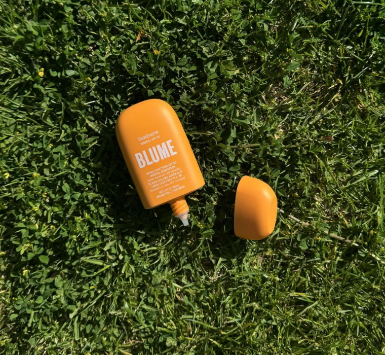  A bottle of Sunburst SPF placed on a flat grass surface
