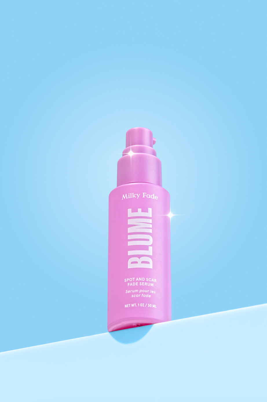 Blume Milky Fade Spot and Scar Fade Serum in pink bottle against blue background