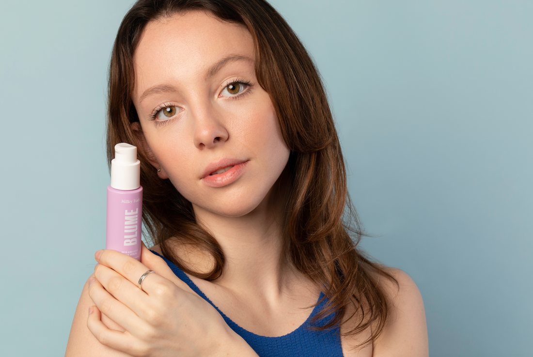 Model holding Blume Milky Fade Serum for fading dark spots and achieving radiant skin.
