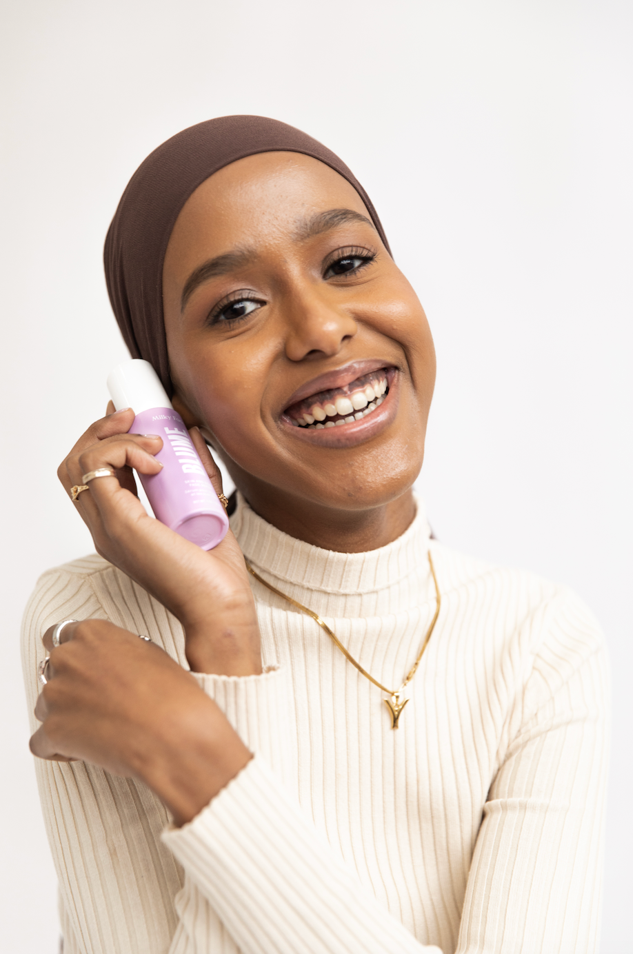 Smiling woman holding Blume Milky Fade Serum for dark spots and acne scars.