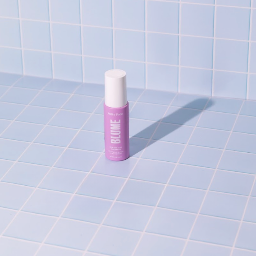 Blume Milky Fade Spot and Scar Serum bottle on light blue tiled background, showcasing skincare product for fading dark spots and acne scars.