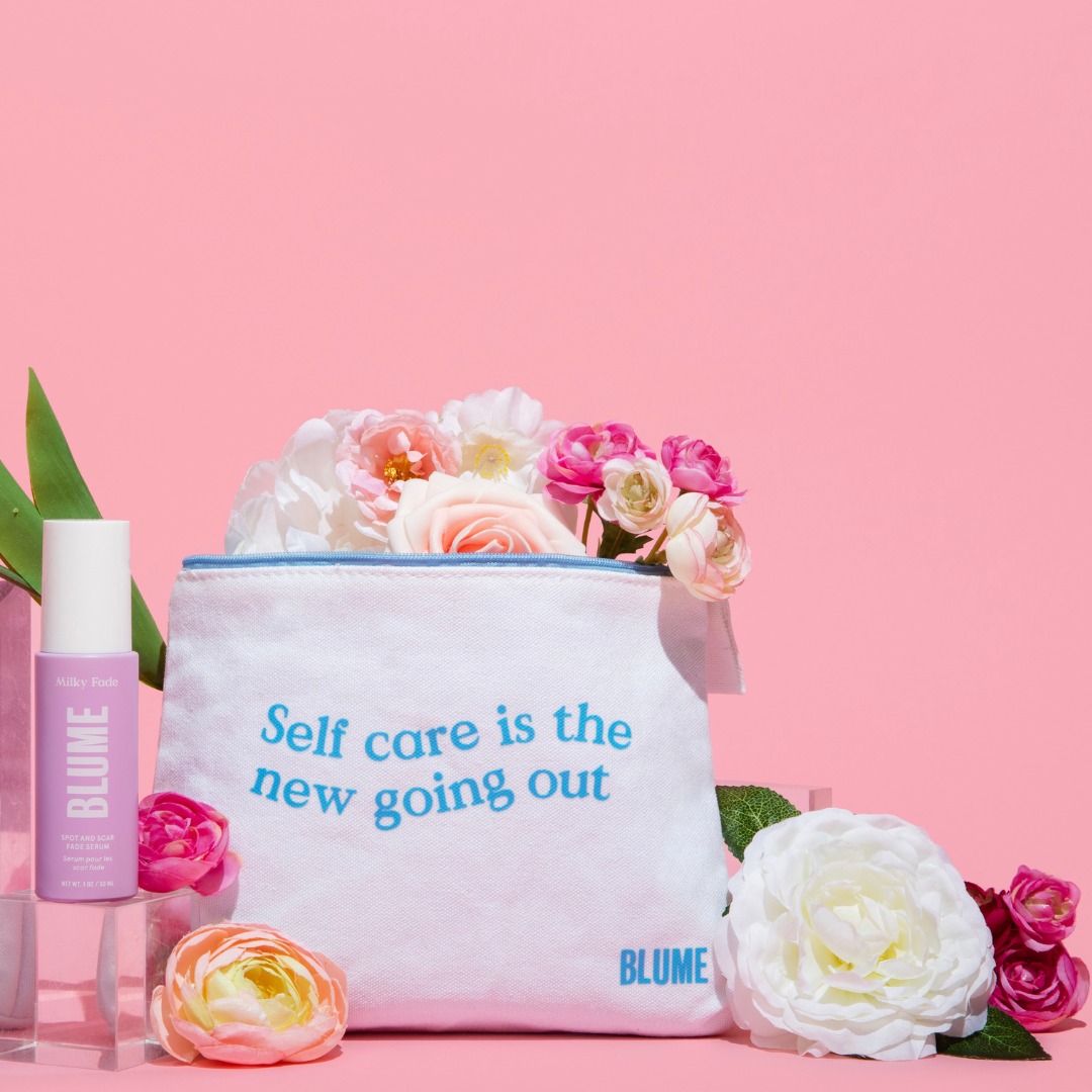 Blume self care kit with Milky Fade serum, cosmetic pouch reading ‘Self care is the new going out,’ and pastel flowers on pink background.
