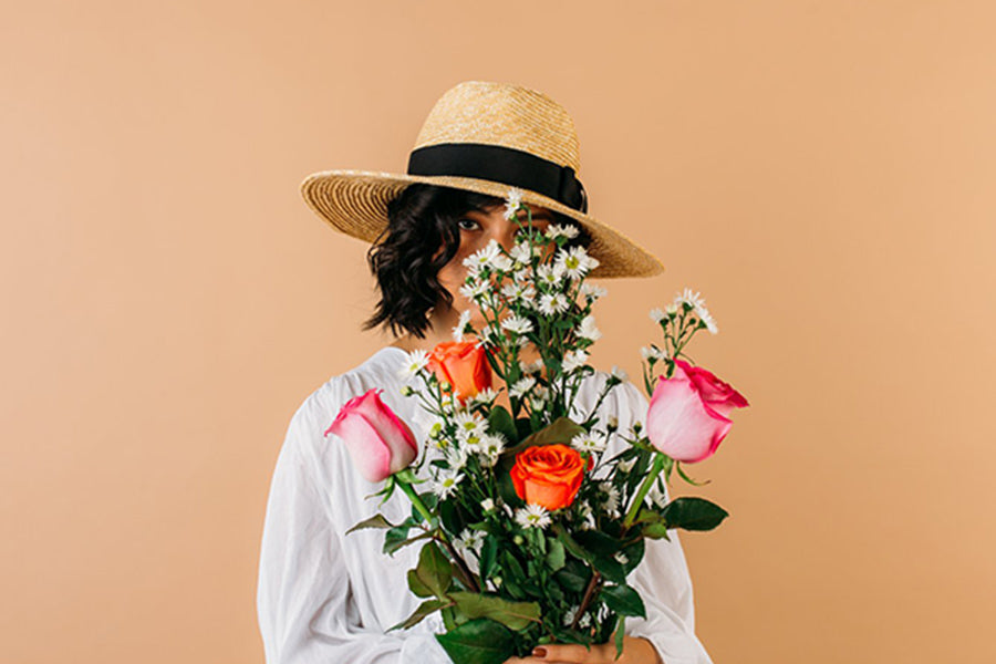 Woman holding Flowers in front of her face